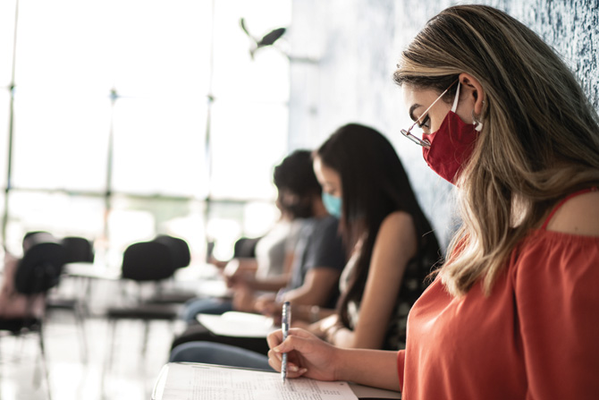 People taking tests during job interview or a test on a university - wearing face mask