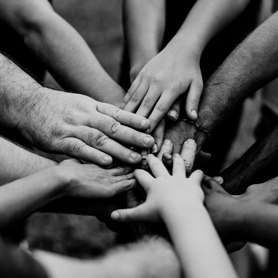 Group of people with hands gathered together in a central point